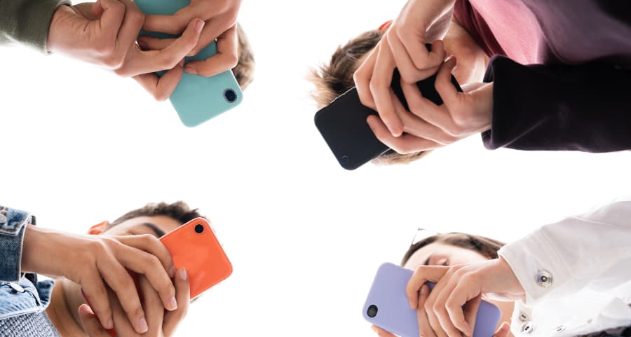Teenagers using smartphones to access social media sites in Sugarland